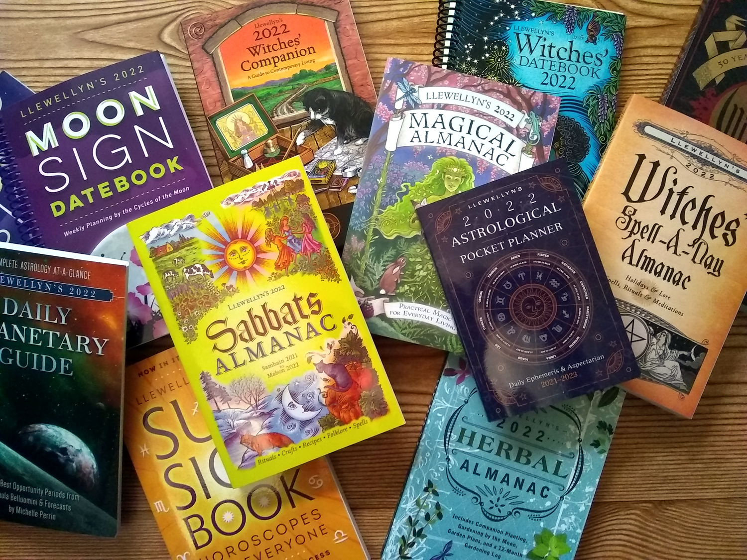 Overhead view of several 2022 Llewellyn's almanacs, datebooks, planners, companions, and guides