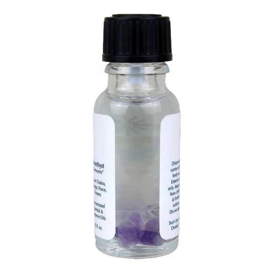 Small glass bottle with a black cap and purple crystals inside on a white background