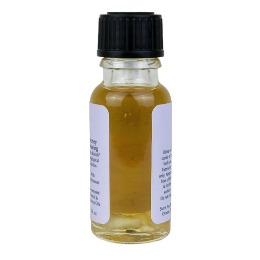 Small glass bottle with yellow liquid and black cap on a white background