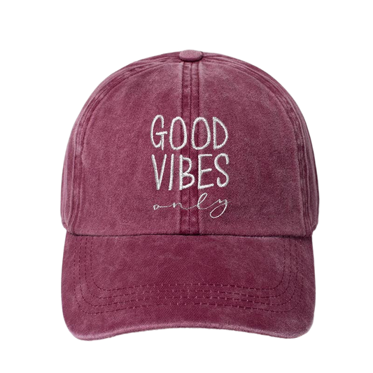 A washed burgandy baseball cap with white embroidered text reading 'GOOD VIBES only' on the front, shown against a plain white background.
